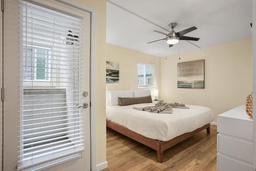 a bedroom with a bed and a ceiling fan at Beach Perfection - Ocean Views, Parking, Pet Friendly & Steps2Sand in San Diego