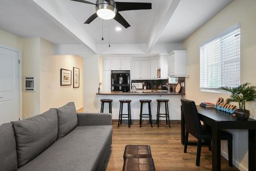a living room with a couch and a table at Stunning Beach Delight with Hot Tub, Fire Pit, Parking & Walk to Beach! in San Diego