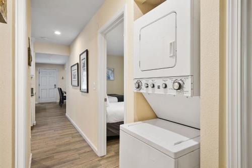 a hallway with a room with a bed and a kitchen at Stunning Beach Delight with Hot Tub, Fire Pit, Parking & Walk to Beach! in San Diego