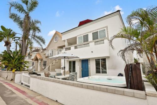 a large white house with a jacuzzi at Stunning Beach Delight with Hot Tub, Fire Pit, Parking & Walk to Beach! in San Diego