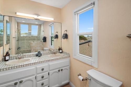 聖地牙哥的住宿－Bay View Paradise - Rooftop Deck, Off-Street Parking, King Suite, WasherDryer & Bay Views!，一间带两个盥洗盆和窗户的浴室