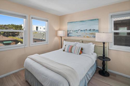 聖地牙哥的住宿－Bay View Paradise - Rooftop Deck, Off-Street Parking, King Suite, WasherDryer & Bay Views!，一间卧室设有一张床和两个窗户。
