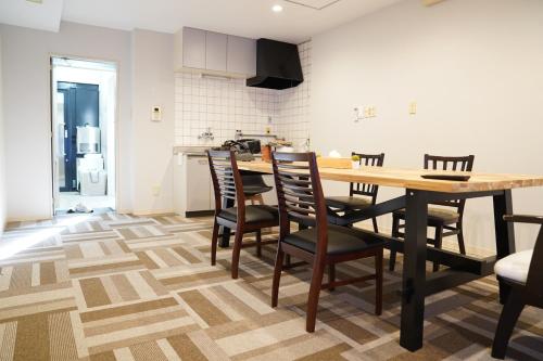 uma cozinha e sala de jantar com uma mesa de madeira e cadeiras em 心斎橋USJ155m2 Party OK JR駅徒歩1分 em Osaka