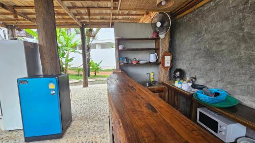 a kitchen with a counter and a blue refrigerator at Eden Lanta Bungalow in Ko Lanta