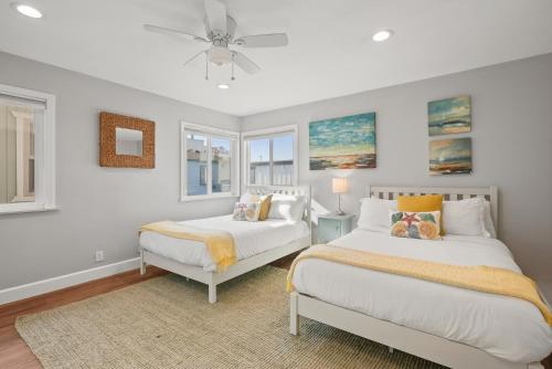a bedroom with two beds and a ceiling fan at Stunning Beach Home with Fireplace, Fast WiFi, Grill & Outdoor Seating! in San Diego