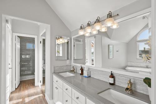 a white bathroom with two sinks and two mirrors at Stunning Beach Home with Fireplace, Fast WiFi, Grill & Outdoor Seating! in San Diego