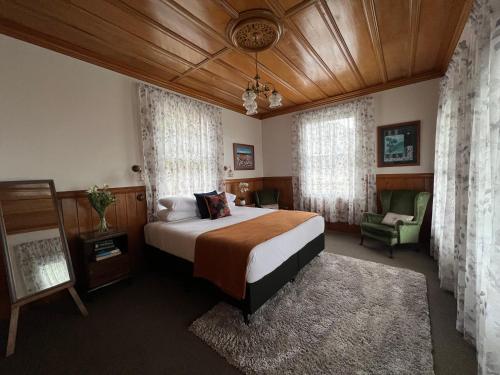 - une chambre avec un grand lit et une chaise dans l'établissement Riverhead Villa, à Horoeke