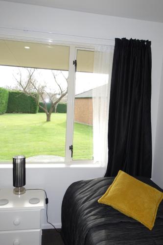 a bedroom with a window with a view of a yard at Northwood Motor Lodge in Christchurch