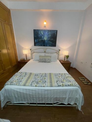 um quarto com uma grande cama branca e 2 candeeiros em Long Bien Homestay em Hanói