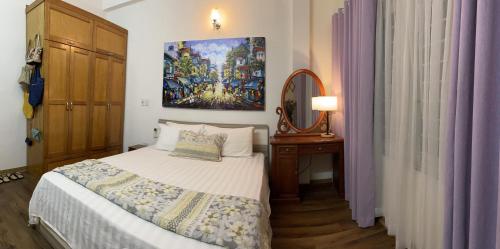 um quarto com uma cama, um espelho e cortinas roxas em Long Bien Homestay em Hanói