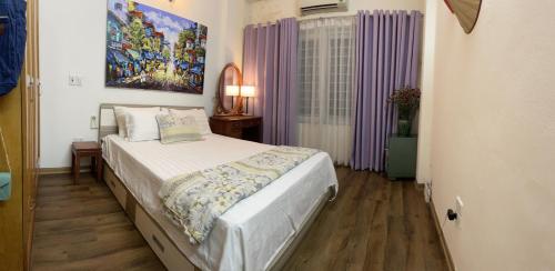 um quarto com uma cama e um quadro na parede em Long Bien Homestay em Hanói