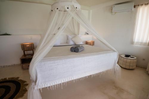 a white bed with a canopy in a room at Rock'n Reef in Uluwatu