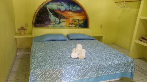 Una cama con un par de toallas blancas. en Casa del sol- alojamiento cerca del embarcadero, en Zihuatanejo