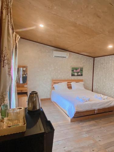 a bedroom with a large bed and a desk with a table at Suannamphukradueng &Suansook Resort in Ban Nong Tum