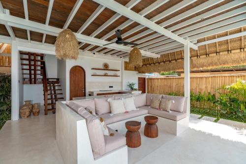 an outdoor living room with a couch and a table at Villa Madu in Nusa Lembongan