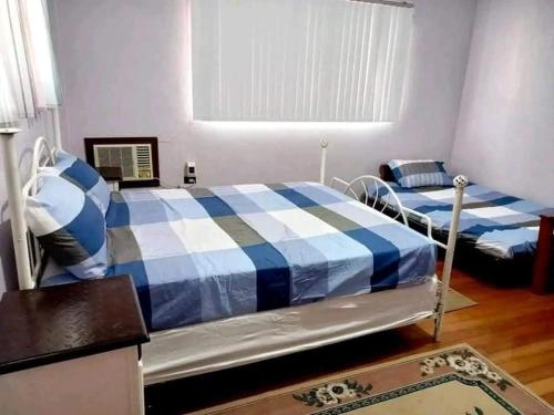 1 dormitorio con 2 camas y ventana en 3B Cozy home, en Mauban