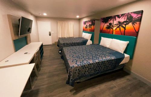 a hotel room with two beds and a flat screen tv at New Star Inn El Monte, CA - Los Angeles in El Monte