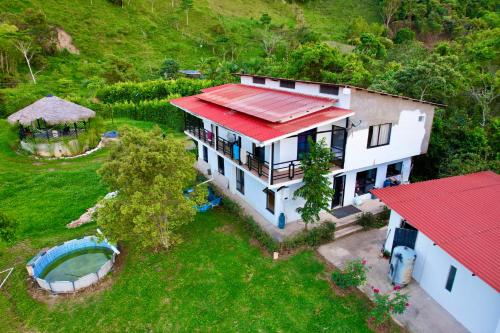 Mountain Lodge La Margarita في Quebradanegra: اطلالة جوية على منزل بسقف احمر
