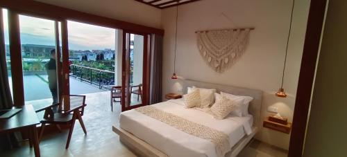 um quarto com uma cama e uma varanda em FULLMOON CANGGU Nelayan em Canggu