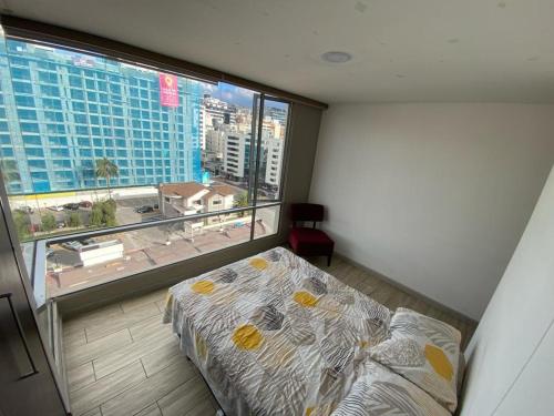 a bedroom with a bed and a large window at Apartamento Sector la Carolina in Quito
