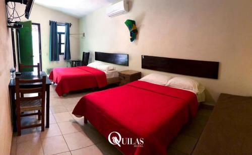 a hotel room with two beds and a table at Hotel Quilas in Huichihuayán