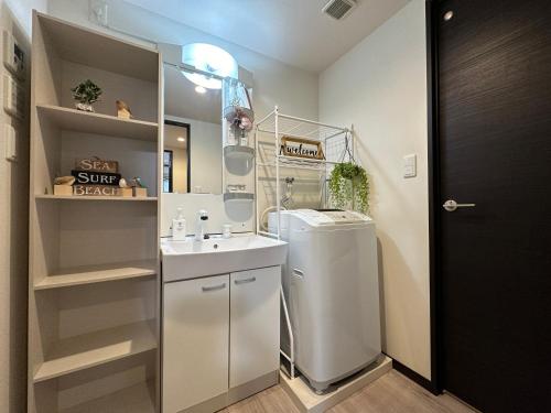 een kleine badkamer met een wastafel en een koelkast bij nestay inn tokyo asakusa in Tokyo