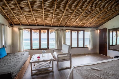 a bedroom with a bed and a chair and a table at Rock'n Reef in Uluwatu