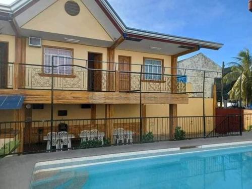 a house with a balcony and a swimming pool at Dantes place in Lumban