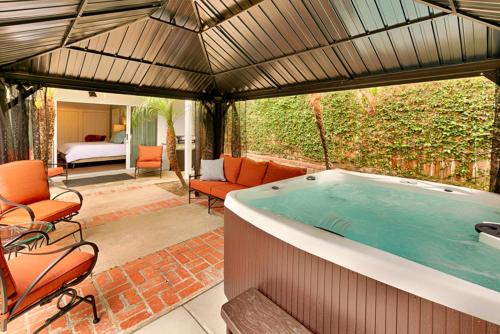 a large hot tub in a room with a patio at Shores Perfection - Spa, AC, Pet Friendly, Parking, Fire Pit & Massive Private Yard! in San Diego