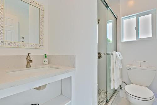 a bathroom with a toilet and a sink and a shower at Shores Perfection - Spa, AC, Pet Friendly, Parking, Fire Pit & Massive Private Yard! in San Diego