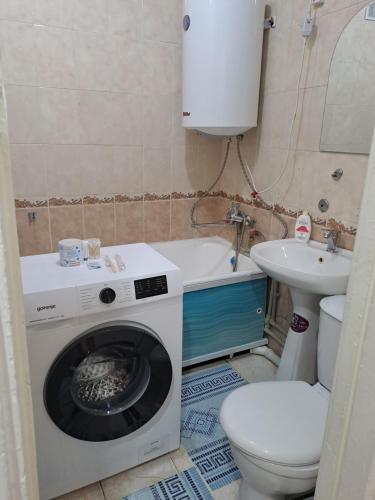 a bathroom with a washing machine and a toilet at 408 квартал in Semey