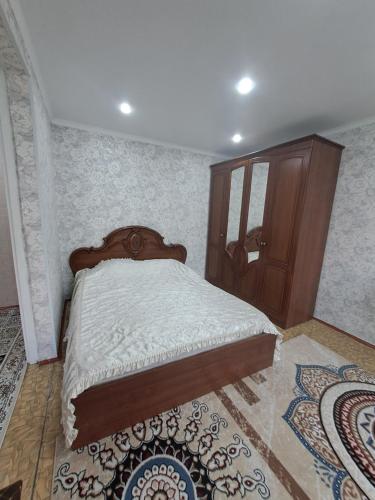 a bedroom with a bed and a wooden cabinet at 408 квартал in Semey