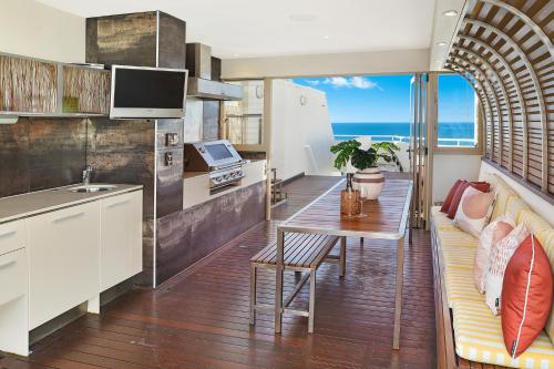 a kitchen and living room with a couch and a table at Osprey Apartments in Mooloolaba