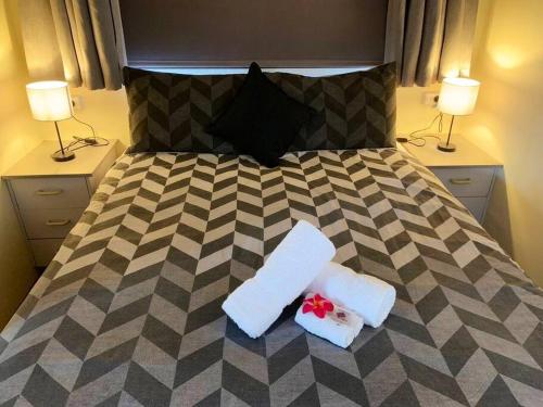 ein Schlafzimmer mit einem Bett mit zwei Handtüchern und zwei Lampen in der Unterkunft The Garden Cottage Pet Friendly in Renmark