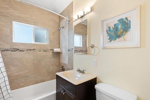 La salle de bains est pourvue d'un lavabo, de toilettes et d'un miroir. dans l'établissement Riviera Bay View Dream - Private patio with bay view and parking, à San Diego