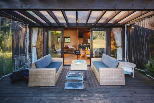 a screened in porch with two couches and a table at THE FARM Resort Japan in Katori