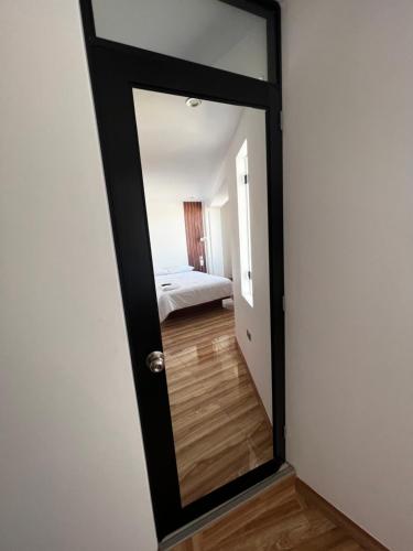 a mirror in a room with a bed at Hotel SOGU TOWER in Ayacucho