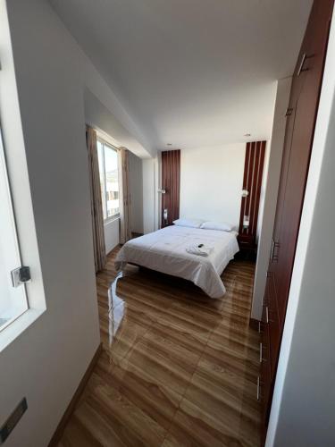 a bedroom with a bed and a large window at Hotel SOGU TOWER in Ayacucho