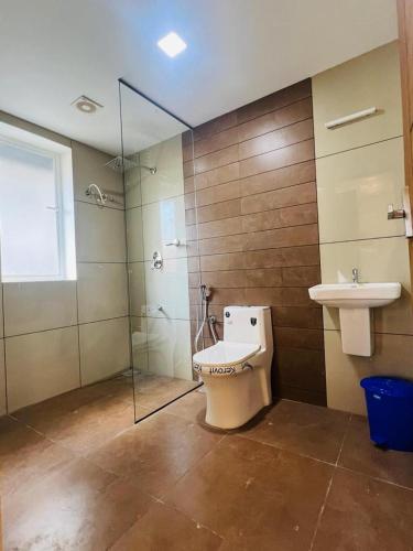 uma casa de banho com um WC, um lavatório e um chuveiro em Cloud Beach Residency em Alappuzha