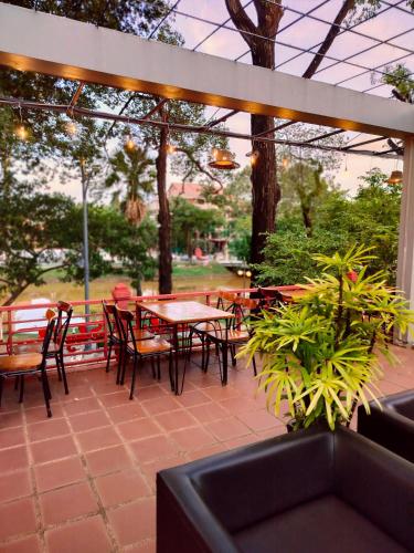 a patio with a table and chairs and a table and chairsktop at La Rivière d' Angkor Resort in Siem Reap