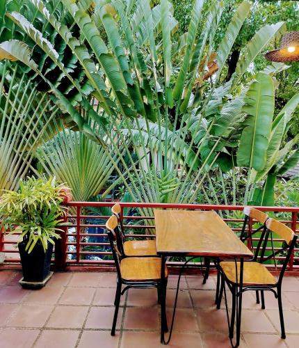 a table and chairs on a patio with plants at La Rivière d' Angkor Resort in Siem Reap