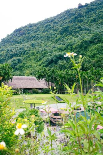 a view of a house with a mountain in the background at Thung Nham Resort in Ninh Binh
