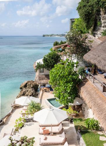 an aerial view of a resort with a swimming pool and the ocean at Rock'n Reef in Uluwatu