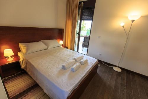 a bedroom with a bed with two towels on it at Apartments Kuce Lekovica Beach & snack bar- Bistro in Bar