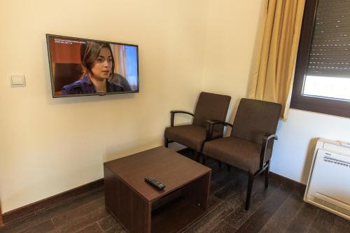 a waiting room with two chairs and a tv on the wall at Apartments Kuce Lekovica Beach & snack bar- Bistro in Bar