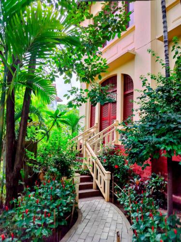 a staircase leading to a house with flowers and plants at La Rivière d' Angkor Resort in Siem Reap