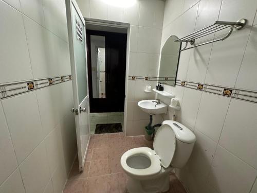 a white bathroom with a toilet and a sink at Xuân An Hotel - 53 Nguyễn Thái Bình, Q. Tân Bình - by Bay Luxury in Ho Chi Minh City