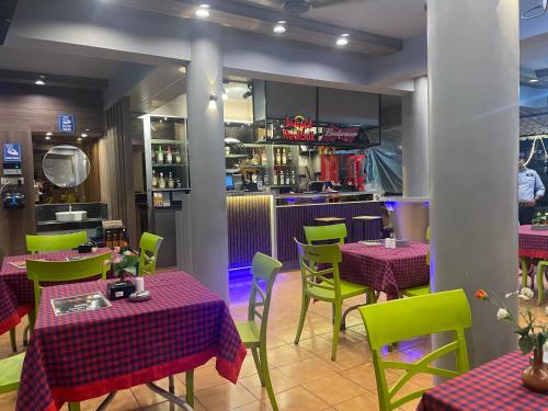 een restaurant met rode en groene tafels en stoelen bij Yellow Sky in Baga