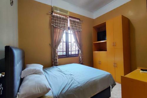 1 dormitorio con cama y ventana en OYO 93390 Griya Pius Syariah Malioboro, en Yogyakarta