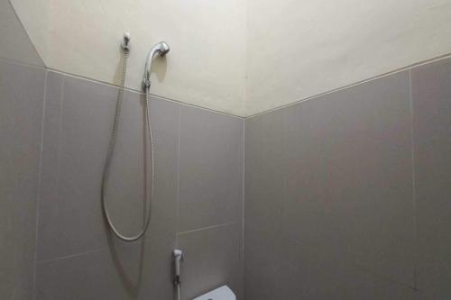 La salle de bains est pourvue d'une douche avec un pommeau de douche. dans l'établissement OYO 93396 Pondok Wisata Sri Mulyo, à Yogyakarta